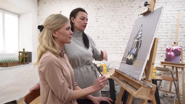 Smiling women painting during workshop in art studio