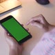 Over the shoulder shot of woman swiping on green screen mobile phone. - VideoHive Item for Sale