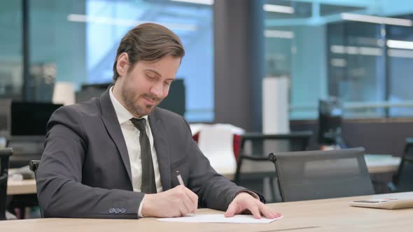 Businessman with Disappointment Writing on Paper