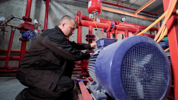 A Water Pumping Station Engineer Repairs the Water Supply Compressor Engine