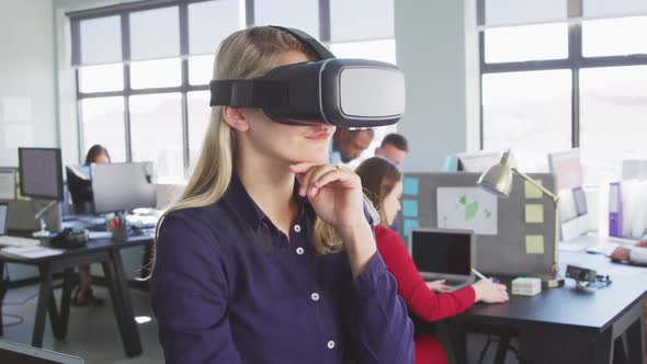 Businesswoman using VR headset in modern office