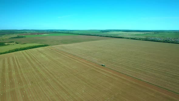 Green Field, the Truck Is Driving in Half. Cultivated Field for Agricultural Work. View From the