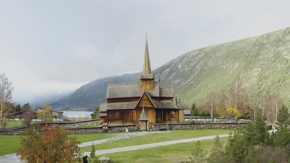Typical Stave Church At Lom Against Majestic Mountains During Snowy Winter In Norway, North-Western