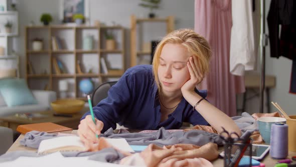 Young Woman Designer Tired While Working on a New Dress