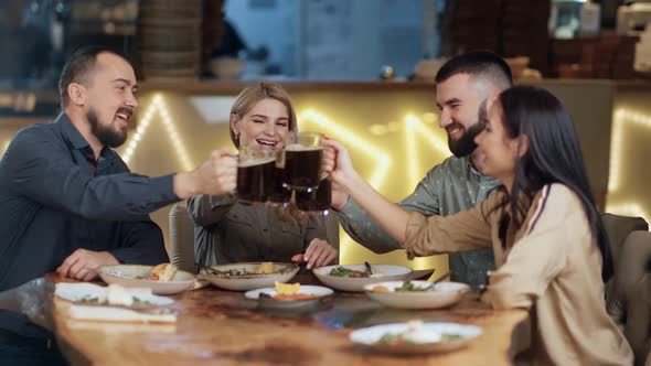 Four Friends Toasting Mug Malt Relaxing in Pub Sitting at Table