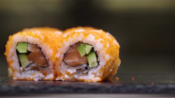Fresh Sushi Rolls Rotating on Black Stone Slate Plate
