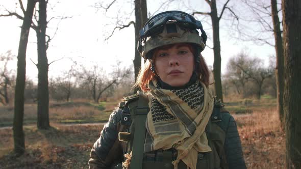 Young Pretty Redhead Woman in Military Uniform Armed with Rifle at the Battlefield Area