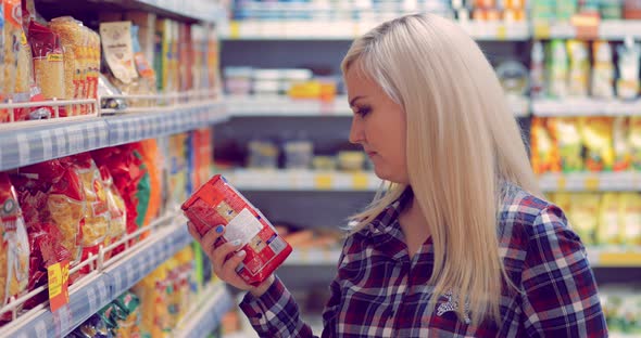 Woman with Shopping Basket Choosing Products in Supermarket