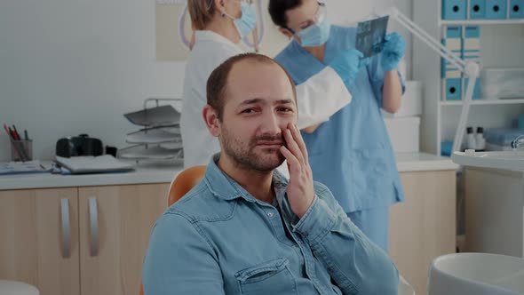 Portrait of Patient with Toothache Looking at Camera in Dentistry Office