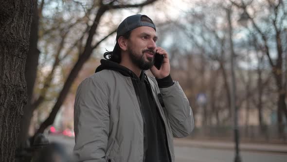 Young Modern Handsome Man Talking on the Phone on the Street on a Sunny Day