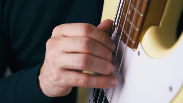Professional Musician Plays Bass Guitar in Vertical Position