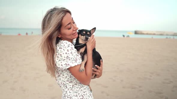 Small Dog Named Artur with Owner, Young Woman, Playing on the Beach