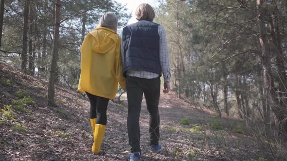 Couple in Love Holding Hands Walking in the Spring Forest