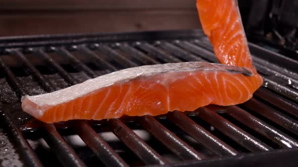 Cook Puts Second Piece of Salmon on Grill