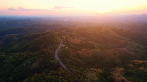 4K Aerial view over mountain scenery at rural Thailand at sunset