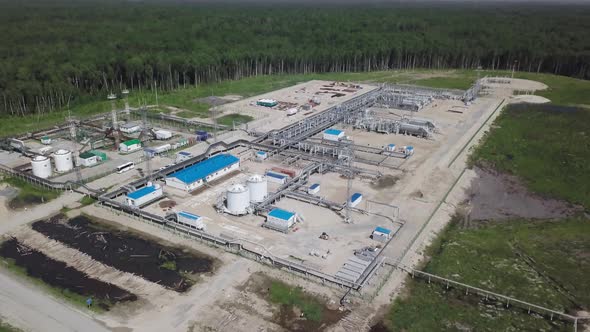 Oil refinery areas of the oil corporation among dense coniferous forests taken from the air