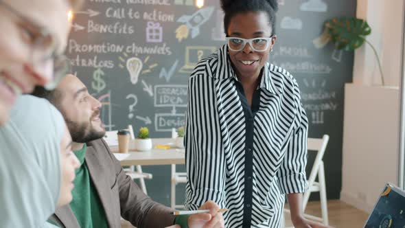 Cheerful Employees Diverse Group Talking and Laughing in Creative Office