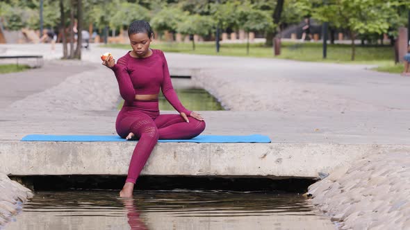 Confident Athletic Millennial African Girl in Sportswear Relaxing on Yoga Mat After Workout