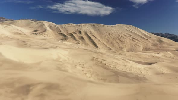 Aerial Establishing Drone Flying Fast Above Sand Dune with Desert Wilderness