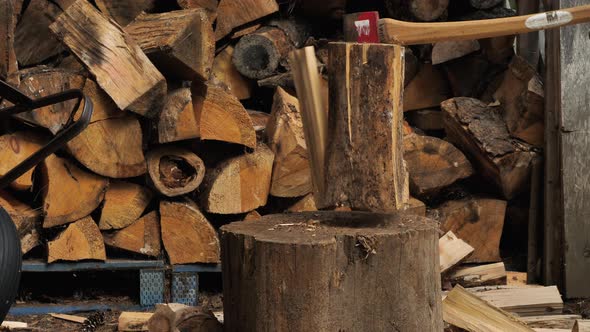 Close up of a man splitting a log with a felling axe in slow motion.