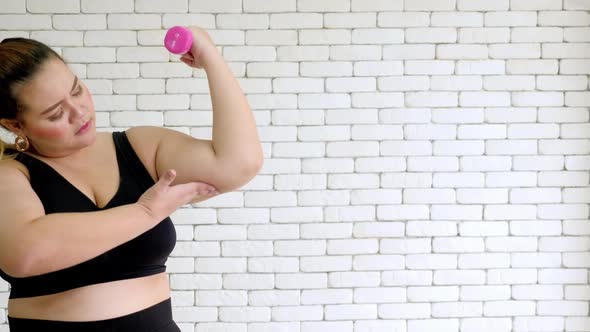 Overweight young woman in sportswear exercising to lose weight at home