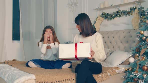 Mother Gives the Child a Big Box with a Christmas Present