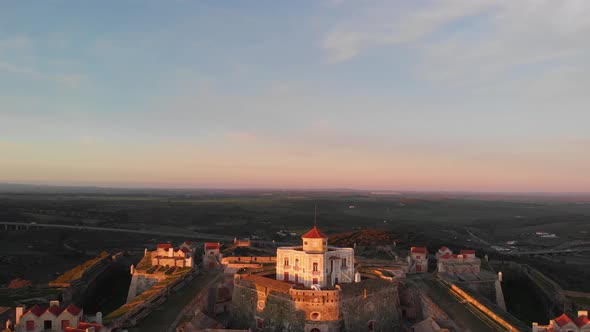 Aerial drone shot lowering towards the ground of a white governor house in the Fort of Nossa Senhora