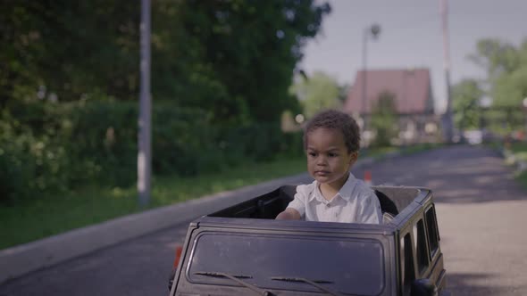 Cute African American Boy in a Toy Car