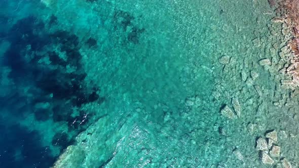 Clear and Shallow Sea Water of the Cove Surrounded by Stone and Rocky Coastline