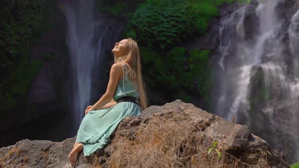 Young Woman Tourist Visits the Biggest Waterfall on the Bali Island - the Sekumpul Waterfall