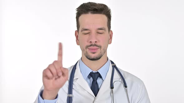 Portrait of Young Male Doctor Saying No with Finger Sign, White Background