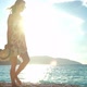 Young woman in dress walking on a beach at sunset - VideoHive Item for Sale