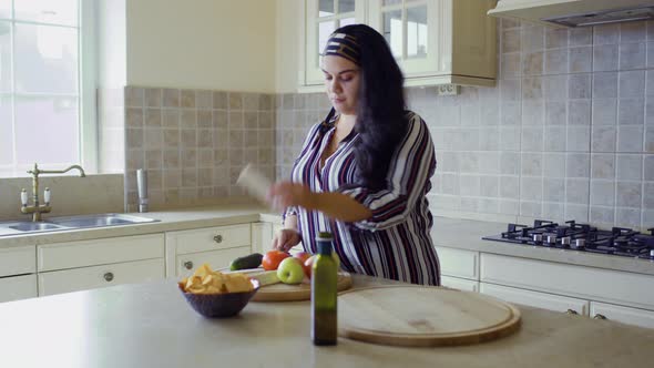 Plump Girl Is Cooking in the Kitchen