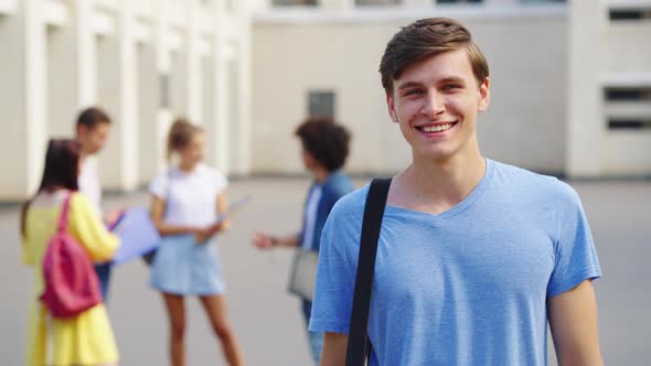 Portrait of student smiling against college building