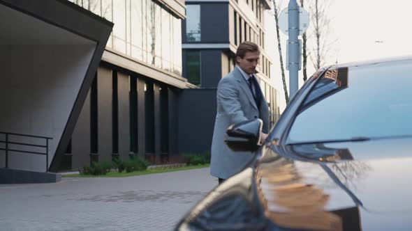 Businessman Walks to a Black Car and Sits in the Passenger Seat an Elegant Man in a Suit Leaves for