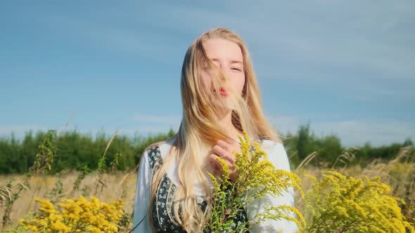 A Young Girl in a Beautiful Dress on a Background of Yellow Wild Flowers