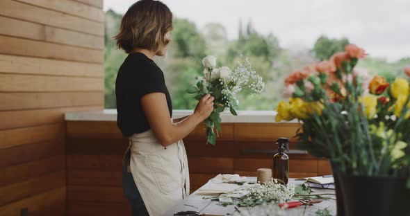 Young woman florist preparing flower bouquet