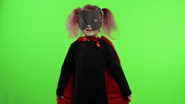 Funny Child Girl in Costume and Mask Plays Super Hero. National Superhero Day