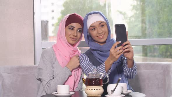 Beautiful Young Muslim Girls Do Selfie on a Smartphone