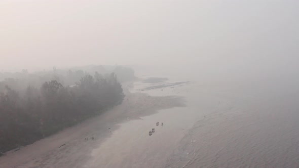 decending drone shot of illegal bullock cart racing on a beach in India