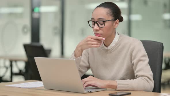 Creative African Woman Thinking Using Laptop