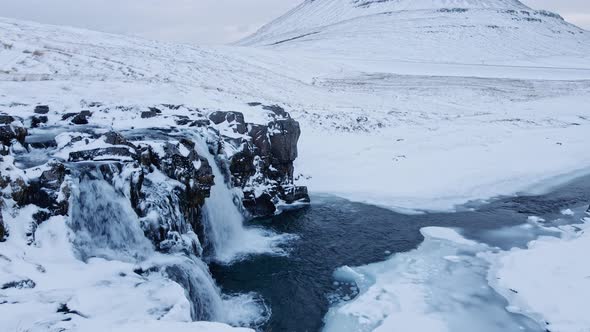 Drone Over Waterfall And Frozen Landscape Towards Kirkjufell