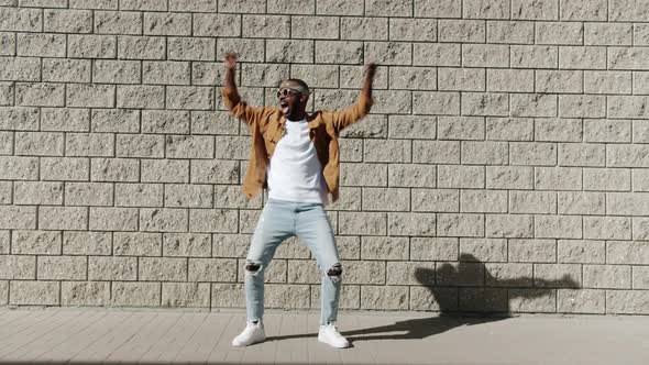 Portrait of Happy AfroAmerican Hiphop Dancer Moving Arms Performing Outdoors