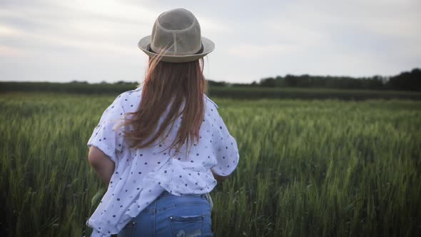 Pretty Child in the Hat Is Running Across the Wheat Field, Happy Young Girl Running in the Field