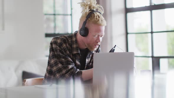 Happy albino african american man with dreadlocks making podcast