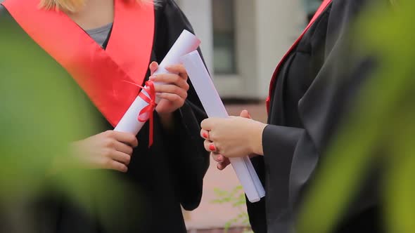 Female Students Holding Diplomas and Chatting in Park, Higher Education