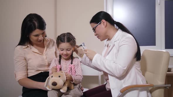 Doctor Examining Ear of Toy Dog and Child