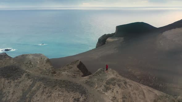 Sportsman Running on Mountain with Capelinhos Volcano on Background