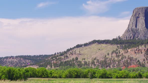 Panning view of Devils Tower in Wyoming as the grass blows