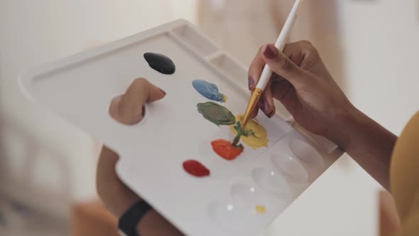 Female Painter Mixing Oil Paints on Palette